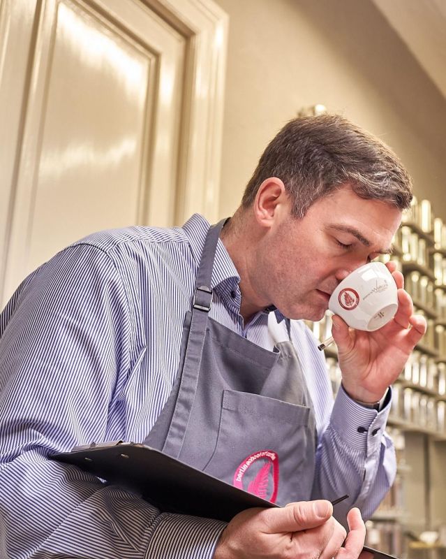 Trainer riecht beim Cupping am Kaffee