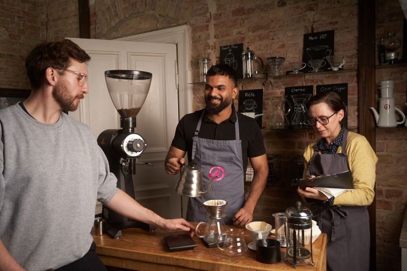 Trainer und Teilnehmende an der Espressomaschine in der Berlin School of Coffee