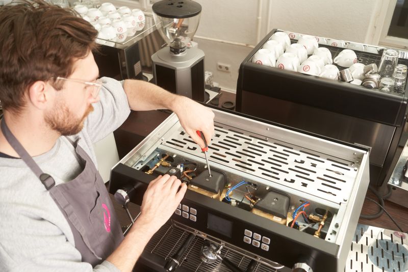 Techniker arbeitet an einer Siebträgermaschine